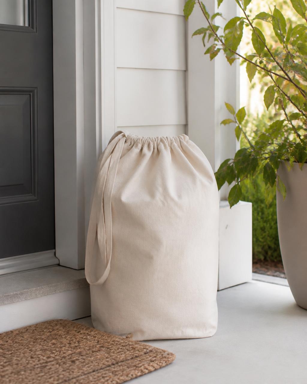 Canvas laundry bag waiting for pickup on a clean front porch